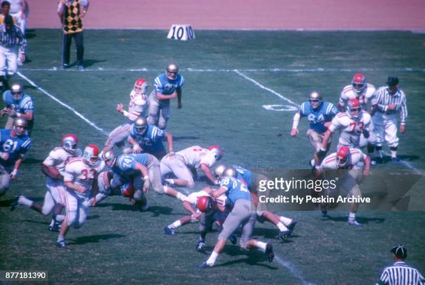 David Francis of the Ohio State Buckeyes blocks for teammate Paul Warfield during an NCAA game against the UCLA Bruins on October 6, 1962 at the Los...