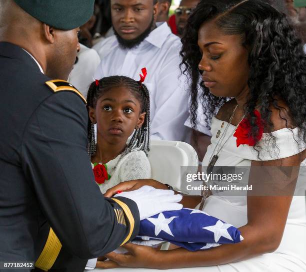 Myeshia Johnson is presented with the U.S. Flag that was draped over the casket of her husband, Sgt. La David Johnson, during his burial service at...