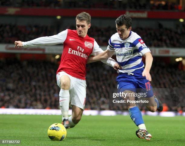 Aaron Ramsey of Arsenal and Joey Barton of Queens Park Rangers battle for the ball during a Barclays Premier League match at the Emirates Stadium on...