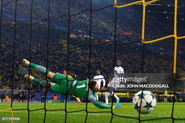 Dortmund's Gabonese forward Pierre-Emerick Aubameyang scores the opening goalpast Tottenham Hotspur's French goalkeeper Hugo Lloris during the UEFA...