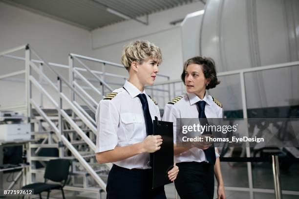 trainee pilot listening to advice from instructor before training session - pilot simulator stock pictures, royalty-free photos & images