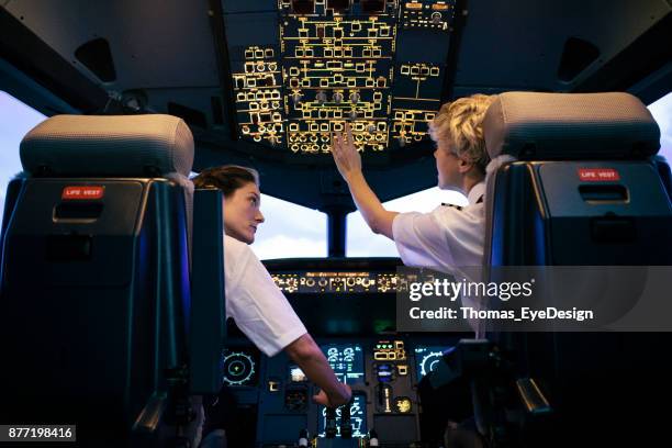 alumno piloto, ajuste de interruptores al mismo tiempo instructor relojes en durante la sesión de simulador - simulador de vuelo fotografías e imágenes de stock