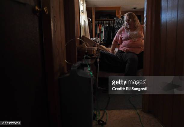 Penny Brott sits on her bed at home on November 15, 2017 in Ordway, Colorado. Diabetes, asthma and essential tremors are a few of Brott's health...