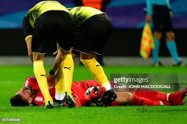 Dortmund's players chcek on their injured Swiss goalkeeper Roman Buerki during the UEFA Champions League Group H football match BVB Borussia Dortmund...