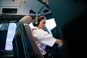Flight Instructor Sitting In Simulator Cockpit Operating Aircraft