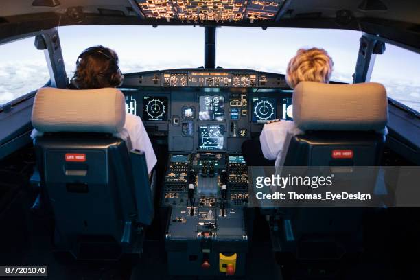 piloto y copiloto, sentados en la cabina del simulador de vuelo - co pilot fotografías e imágenes de stock