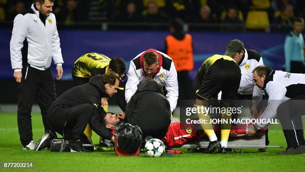 Dortmund's Swiss goalkeeper Roman Buerki is stretchered off by medical staff during the UEFA Champions League Group H football match BVB Borussia...