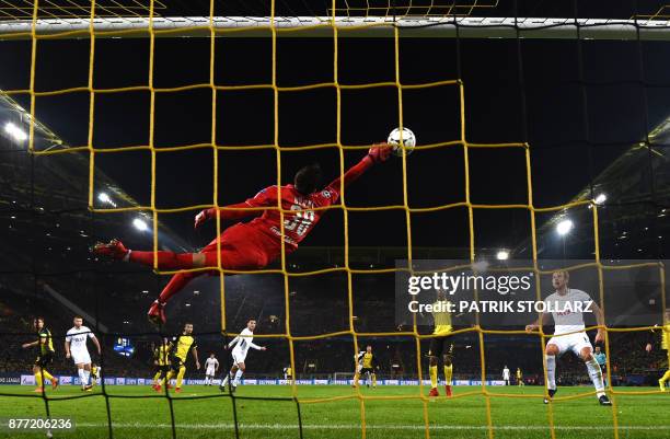 Tottenham Hotspur's English striker Harry Kane looks on as Dortmund's Swiss goalkeeper Roman Buerki flys through the air to make a save during the...