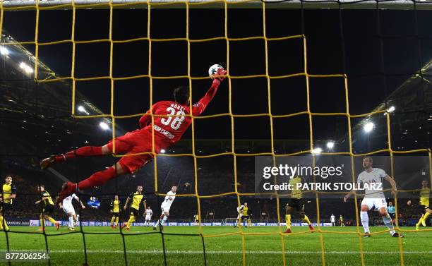 Tottenham Hotspur's English striker Harry Kane looks on as Dortmund's Swiss goalkeeper Roman Buerki flys through the air to make a save during the...