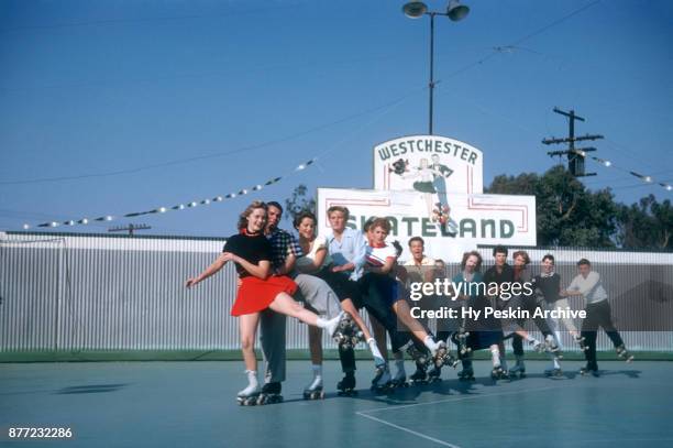 General view of Gloria and her friends roller skating in a conga line circa November, 1954 at the Westchester SkateLand in Westchester, New York.