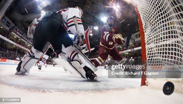 Aapeli Räsänen of the Boston College Eagles swings at the puck before it enters the net on a goal by teammate Jesper Mattila behind Cayden Primeau of...