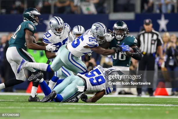 Philadelphia Eagles running back Jay Ajayi is hit by Dallas Cowboys safety Xavier Woods and linebacker Anthony Hitchens during the game between the...