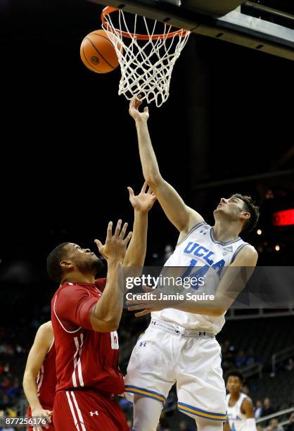 Gyorgy Goloman of the UCLA Bruins grabs a rebound over Charles Thomas IV of the Wisconsin Badgers during the National Collegiate Basketball Hall Of...