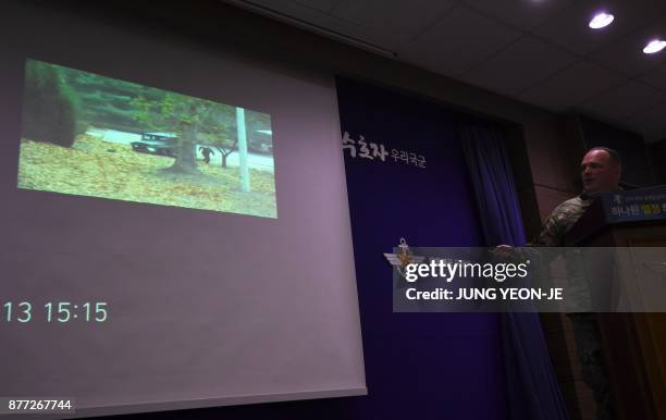 United Nations Command spokesman Colonel Chad G. Carroll shows a surveillance TV footage containing the moment of defection of a North Korean...