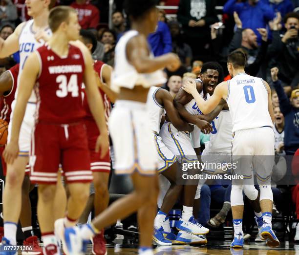 Aaron Holiday of the UCLA Bruins is mobbed by teammates after making a three-pointer at the end of the National Collegiate Basketball Hall Of Fame...