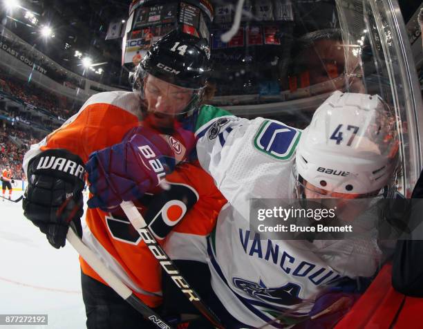Sean Couturier of the Philadelphia Flyers checks Sven Baertschi of the Vancouver Canucks into the glass during the third period at the Wells Fargo...