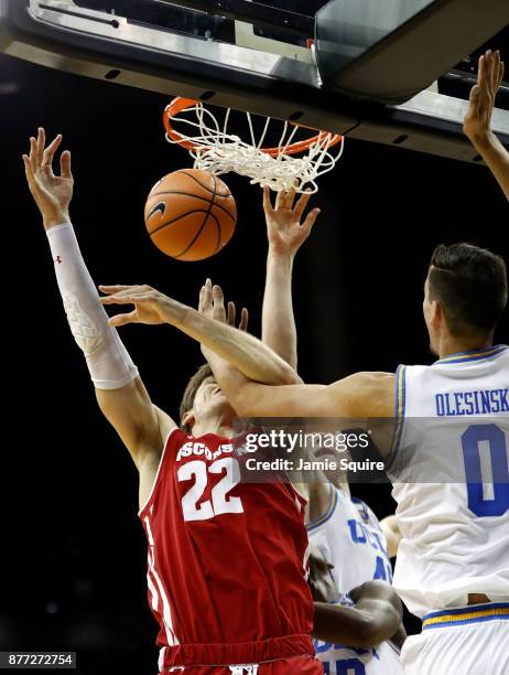 Ethan Happ of the Wisconsin Badgers is fouled by Alex Olesinski of the UCLA Bruins while shooting during the National Collegiate Basketball Hall Of...