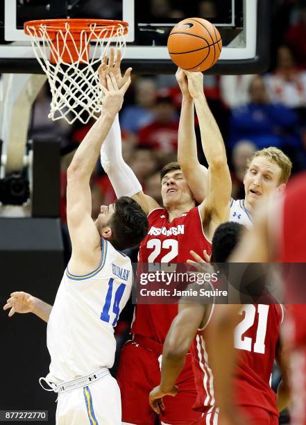 Ethan Happ of the Wisconsin Badgers battles Gyorgy Goloman and Thomas Welsh of the UCLA Bruins for a rebound during the National Collegiate...