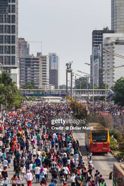 a huge crowd attends the car free day along sudirman street in jakarta, indonesia capital city - sudirman stock pictures, royalty-free photos & images