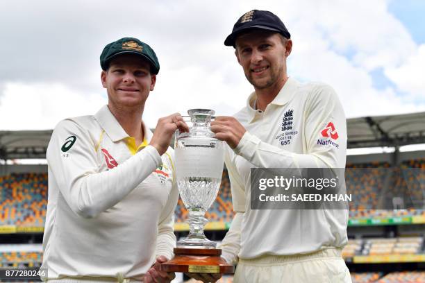 Australia's skipper Steve Smith and England captain Joe Root smile as they pose at a media opportunity in Brisbane on November 22 ahead of the first...