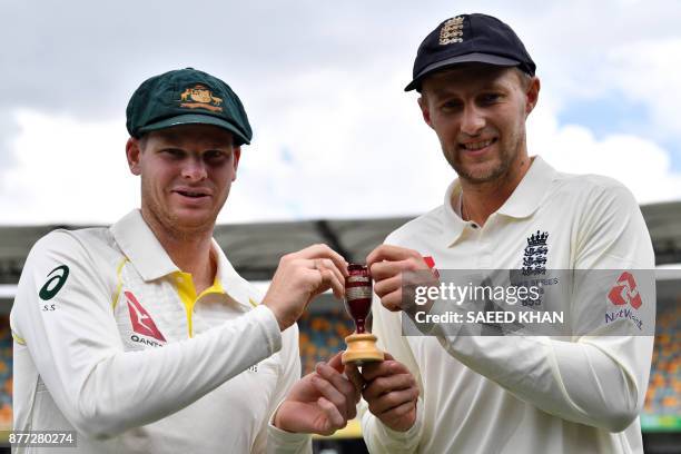 Australia's skipper Steve Smith and England captain Joe Root hold a replica Ashes Urn as they pose at a media opportunity in Brisbane on November 22...