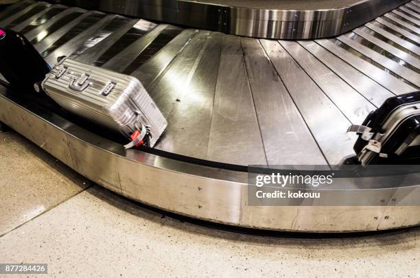 saco do rolo de bagagem fluindo com carrossel. - área de retirada de bagagem - fotografias e filmes do acervo
