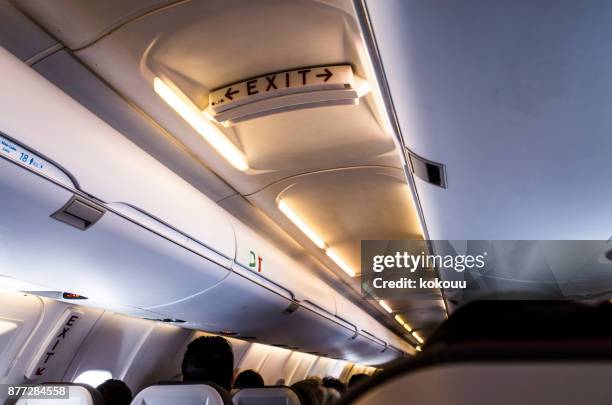 im flugzeug. - gepäckablage stock-fotos und bilder