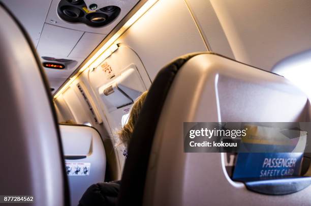 im flugzeug. - gepäckablage stock-fotos und bilder