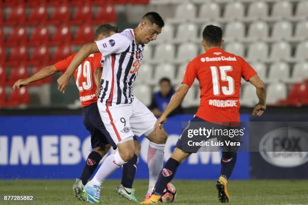 Oscar Cardozo of Libertad fights for the ball with Diego Rodriguez and Nicolas Domingo of Independiente during a first leg match between Libertad and...