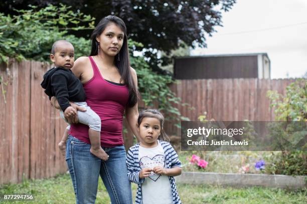 modern native american mom and two children in backyard - indian family portrait stockfoto's en -beelden