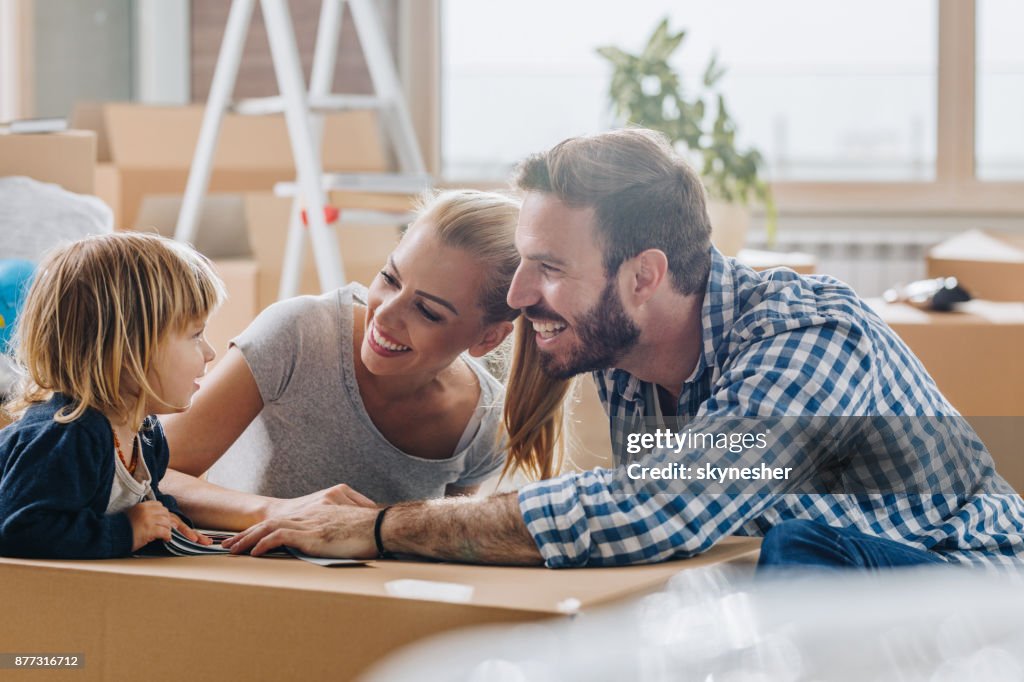 Happy parents talking to their son while moving into new home.