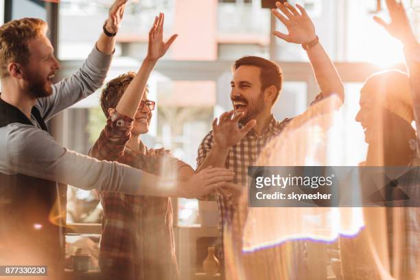 cheerful business team celebrating their success in the office. - place of work celebrate stock pictures, royalty-free photos & images