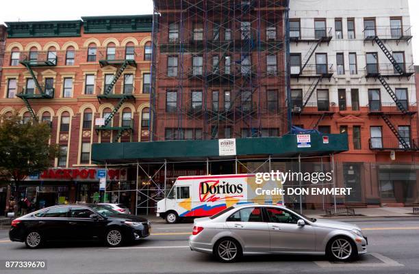 Cars wait at a stoplight on 116th St. In Harlem as building reconstruction takes place November 14, 2017 in New York. Harlem was the neighborhood...