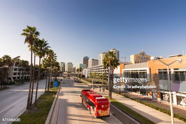 red electric bus driving in downtown long beach, ca - downtown long beach california stock pictures, royalty-free photos & images