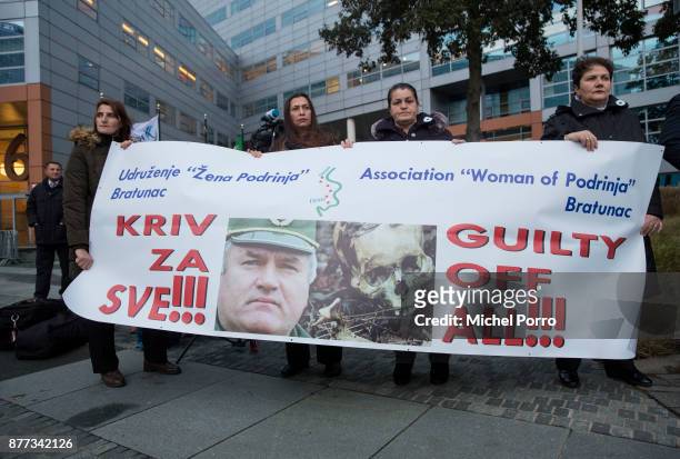 Protesters stand outside the court before former Bosnian military chief Ratko Mladic appears for the pronouncement of the Trial Judgement for the...