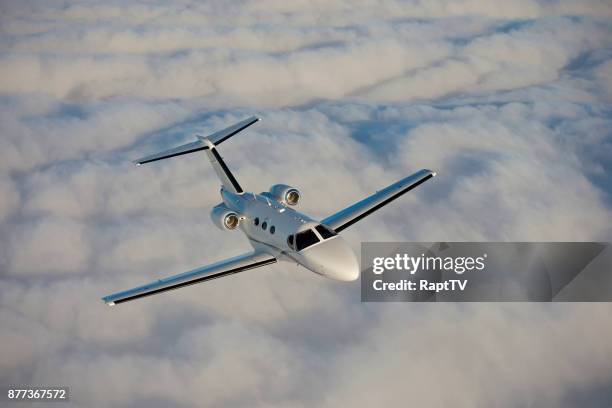 a private airplane flying above the clouds. - billionaires stock pictures, royalty-free photos & images