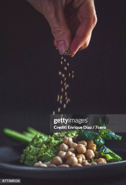 sesame seeds sprinkled on green hummus - strooisels stockfoto's en -beelden