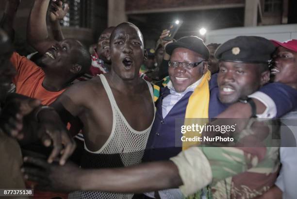 Zimbabweans drink, sing, and dance as they celebrate at night at an intersection in downtown Harare, Zimbabwe Tuesday, Nov. 21, 2017. Mugabe resigned...