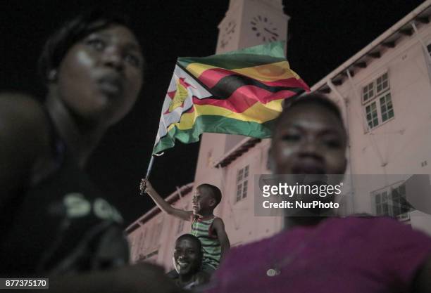 Zimbabweans drink, sing, and dance as they celebrate at night at an intersection in downtown Harare, Zimbabwe Tuesday, Nov. 21, 2017. Mugabe resigned...