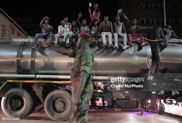 Zimbabweans drink, sing, and dance as they celebrate at night at an intersection in downtown Harare, Zimbabwe Tuesday, Nov. 21, 2017. Mugabe resigned...