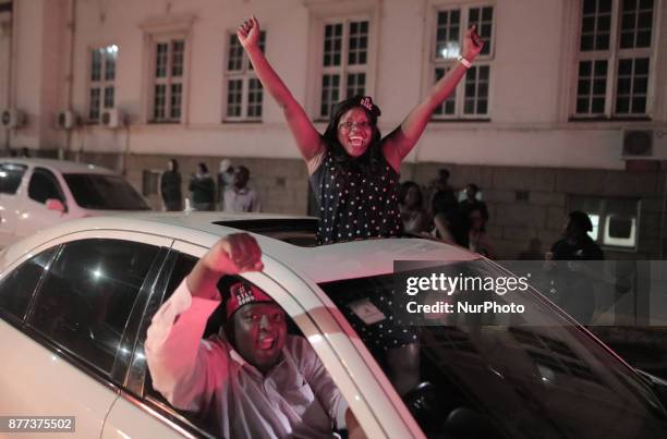 Zimbabweans drink, sing, and dance as they celebrate at night at an intersection in downtown Harare, Zimbabwe Tuesday, Nov. 21, 2017. Mugabe resigned...