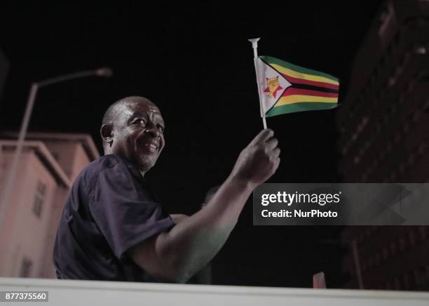 Zimbabweans drink, sing, and dance as they celebrate at night at an intersection in downtown Harare, Zimbabwe Tuesday, Nov. 21, 2017. Mugabe resigned...