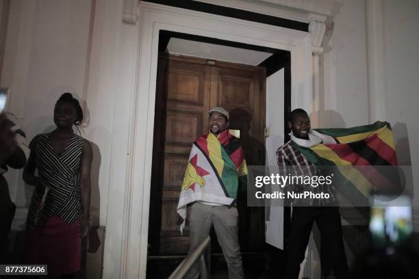 Zimbabweans drink, sing, and dance as they celebrate at night at an intersection in downtown Harare, Zimbabwe Tuesday, Nov. 21, 2017. Mugabe resigned...