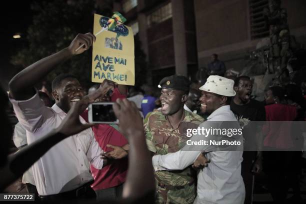 Zimbabweans drink, sing, and dance as they celebrate at night at an intersection in downtown Harare, Zimbabwe Tuesday, Nov. 21, 2017. Mugabe resigned...