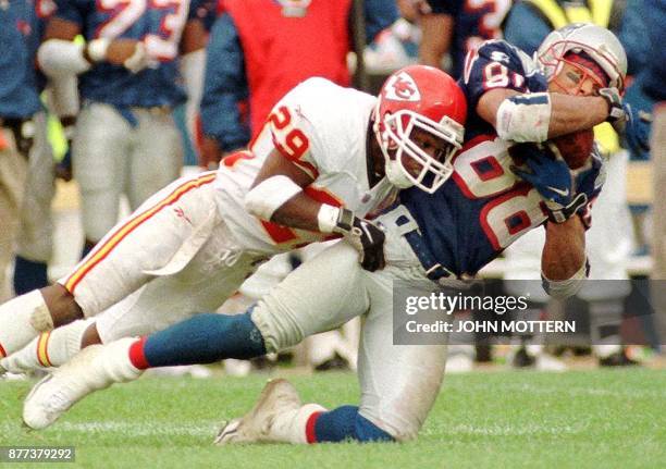 New England Patriot Terry Glen is brought down by Kansas City Chief Mark McMillan in the third quarter of action 11 October at Foxboro Stadium in...