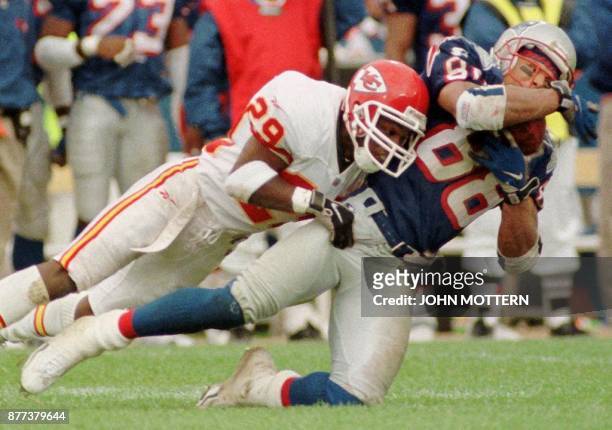 New England Patriot Terry Glen is brought down by as Kansas City Chief Mark McMillan in the third quarter of action 11 October at Foxboro Stadium in...