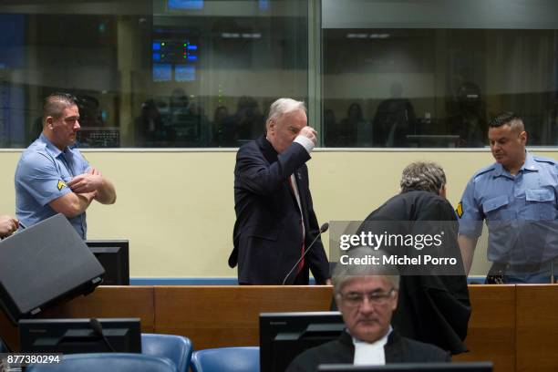 Former Bosnian military chief Ratko Mladic makes the sign of the cross over himself before appearing for the pronouncement of the Trial Judgement for...