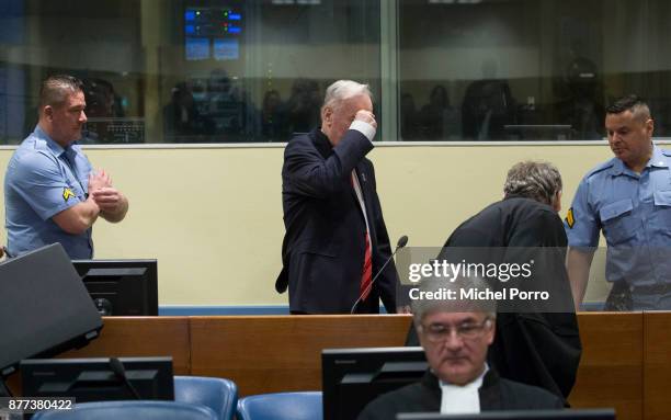Former Bosnian military chief Ratko Mladic makes the sign of the cross over himself before appearing for the pronouncement of the Trial Judgement for...