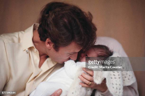 French singer and actor Johnny Hallyday with his newborn daughter Laura Smet, 25th November 1983