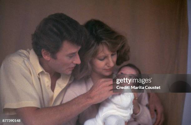 French actress Nathalie Baye and partner, singer and actor Johnny Hallyday with their newborn baby girl, Laura Smet, 25th November 1983